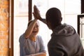 African guy and caucasian girl giving high five meet at cafe Royalty Free Stock Photo