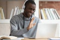 African guy in headphones makes videocall greeting online tutor
