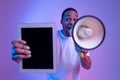 African Guy With Loudspeaker Holding Digital Tablet With Black Screen, Making Announcement Royalty Free Stock Photo