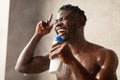 African Guy Singing Taking Shower Holding Shampoo Bottle In Bathroom Royalty Free Stock Photo