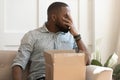 African guy feels stressed saw that goods in parcel damaged Royalty Free Stock Photo