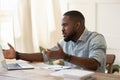 African guy looks at pc screen talking feels outraged