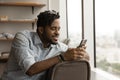 African guy take break at modern office using smartphone