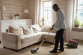 African guy use vacuum cleaner cleaning carpet in living room Royalty Free Stock Photo