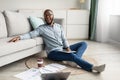 African Guy Using Digital Tablet Sitting On Floor At Home Royalty Free Stock Photo