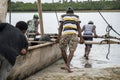 African Guys are Pushing a traditional boat into the Water at Pemba island, Zanzibar, Tanzania