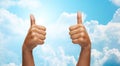 African hands showing thumbs up over blue sky Royalty Free Stock Photo