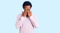 African handsome man wearing casual pink shirt with sad expression covering face with hands while crying Royalty Free Stock Photo