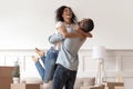 African husband lifting happy wife celebrating moving day with boxes Royalty Free Stock Photo