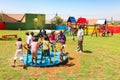 African kids playing merry go round and other park equipment at local public playground