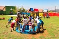 African kids playing merry go round and other park equipment at local public playground