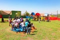 African kids playing merry go round and other park equipment at local public playground