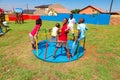 African kids playing merry go round and other park equipment at local public playground