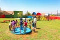 African kids playing merry go round and other park equipment at local public playground Royalty Free Stock Photo