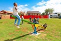 African kids playing on Seesaw and other park equipment at local public playground