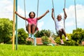 African kids playing on swing in neighborhood.
