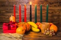 african Kwanzaa festive concept with decorative candles red, black and green, gift box, pumpkins, ears