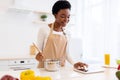 African Lady Cooking Using Tablet Computer Preparing Dinner In Kitchen Royalty Free Stock Photo