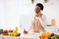 African Lady Cooking Talking On Cellphone Writing Recipes In Kitchen Royalty Free Stock Photo