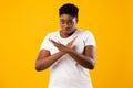 African Lady Crossing Hands Showing Forbidding Gesture, Yellow Background