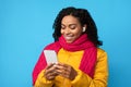 African Lady In Earbuds Listening Music On Smartphone, Blue Background Royalty Free Stock Photo