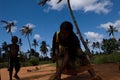 An African lady holding a coconut in order to slice the top