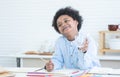 African little boy with afro hair drinking milk from glass, smiling with milk mustache, standing in kitchen at home while playing Royalty Free Stock Photo