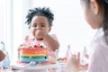 African little cute child girl enjoy eating rainbow cake, sugar candies and jelly on birthday party with hand and fork. Kids have Royalty Free Stock Photo