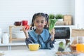 African little kid girl having fun with food and vegetables at kitchen, holding tomato and green vegetable. Cute child preparing Royalty Free Stock Photo