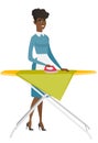 African maid ironing clothes on ironing board. Royalty Free Stock Photo