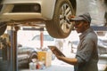 African maintenance male checking tire service via insurance system at garage with using tablet