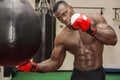 African male boxer punching ball wearing boxing