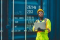 African male dock worker control loading containers cargo at warehouse container shipyard. Marine and carrier staff employee.