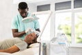 African male doctor uses scriber beauty machine nozzle for gentle skin peeling for man client