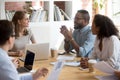 African male employee speaking sharing ideas at diverse team meeting