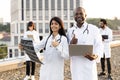 African male with laptop and young Indian female doctor with stethoscope Royalty Free Stock Photo