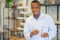 African male optician standing with arms crossed in optical store. Eye doctor, optometris at work Royalty Free Stock Photo