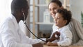 African male pediatrician hold stethoscope exam child boy patient Royalty Free Stock Photo