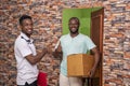 African male receiving a parcel from a delivery service worker