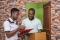 African male receiving a parcel from a delivery service worker