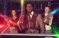 African male and jolly women holding laser guns