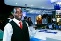 African male waiter holding a tray of drinks in a bar in Johannesburg, South Africa