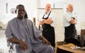 African man approving result of hairdresser work