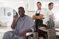 African man approving result of hairdresser work