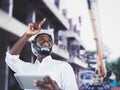 African man architect at building site. African American Engineer man use tablet device standing communication at construction Royalty Free Stock Photo