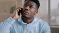 African man businessman american male employee worker answer incoming call talking on phone in home office disappointed