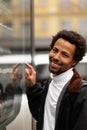 African man buys drink or sweets at vending machine outside