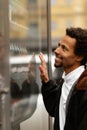 African man buys drink or sweets at vending machine outside