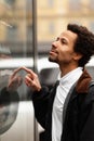 African man buys drink or sweets at vending machine outside