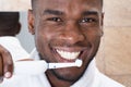 African Man Cleaning His Teeth In Front Of Mirror Royalty Free Stock Photo